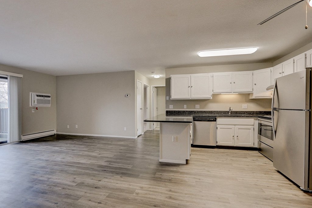 an empty kitchen with white cabinets and stainless steel appliances