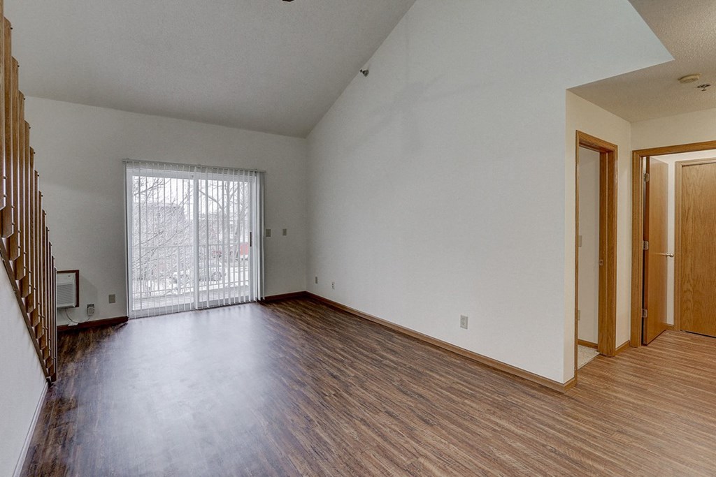 the living room of an empty house with wood flooring