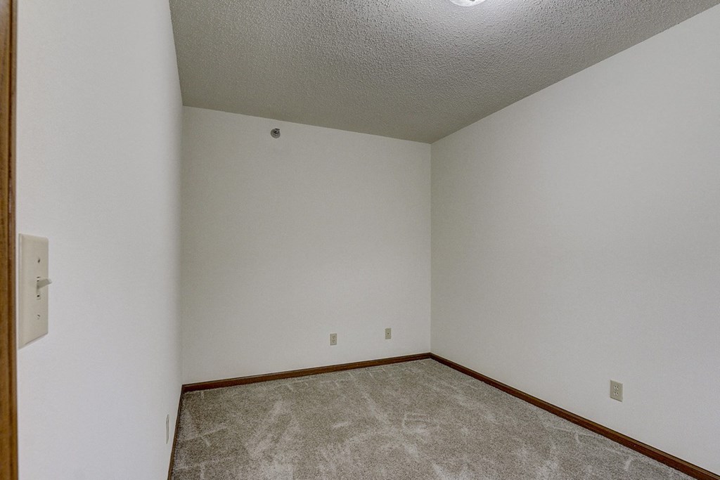 an empty room with carpet and white walls