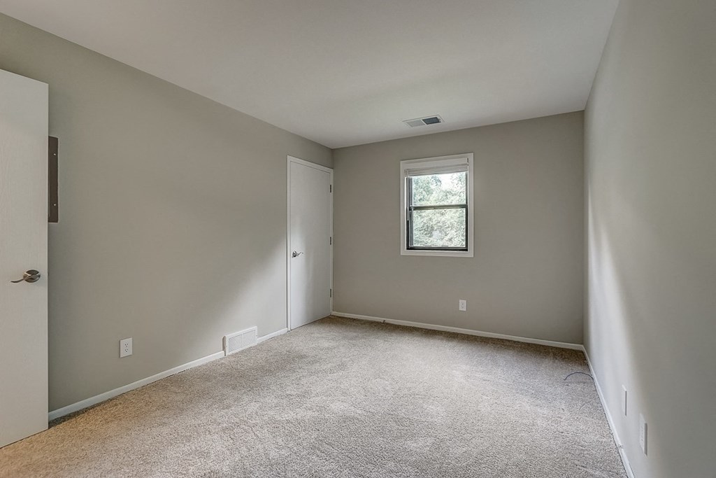 an empty room with carpet and a window