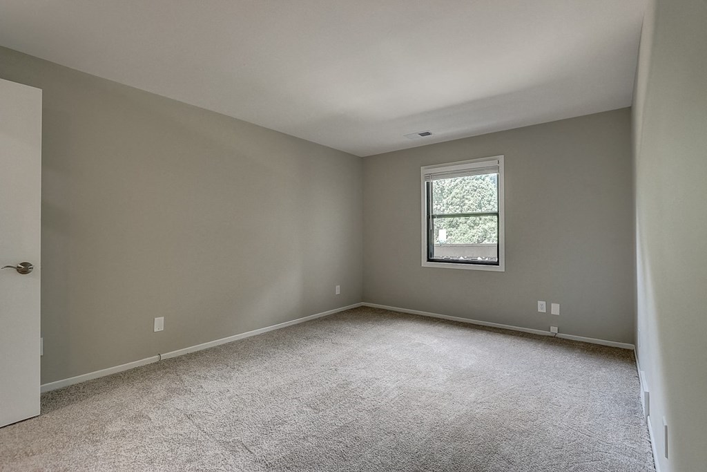 an empty room with carpet and a window