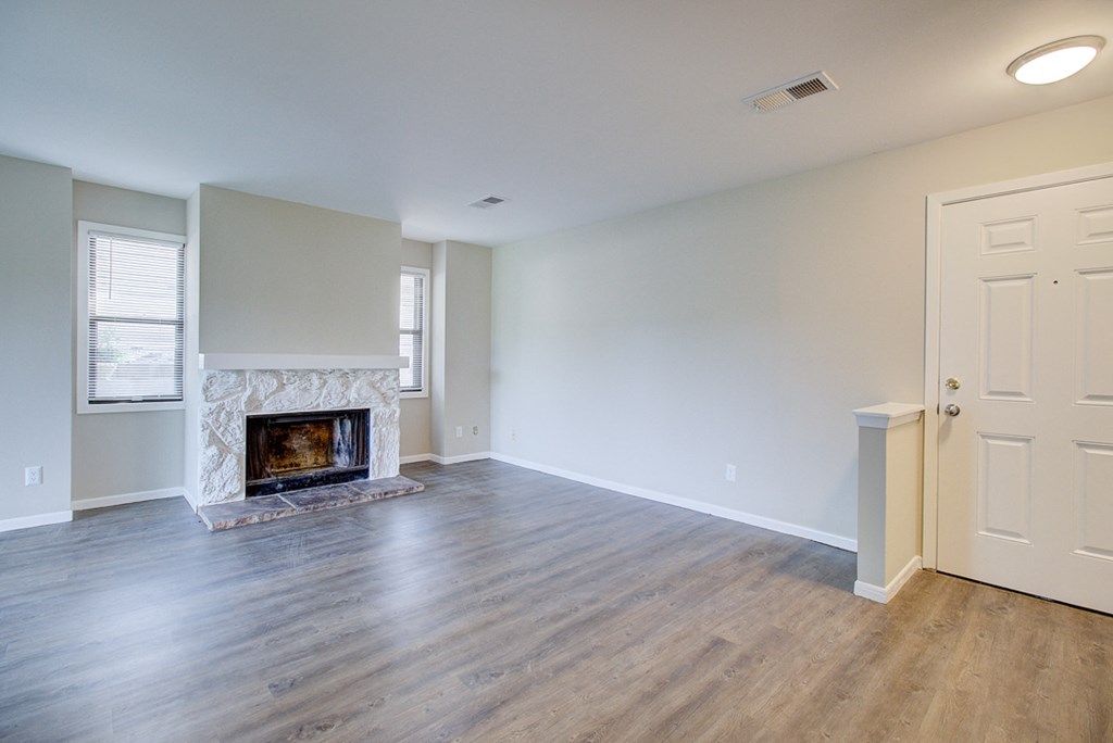 an empty living room with a fireplace and a white door