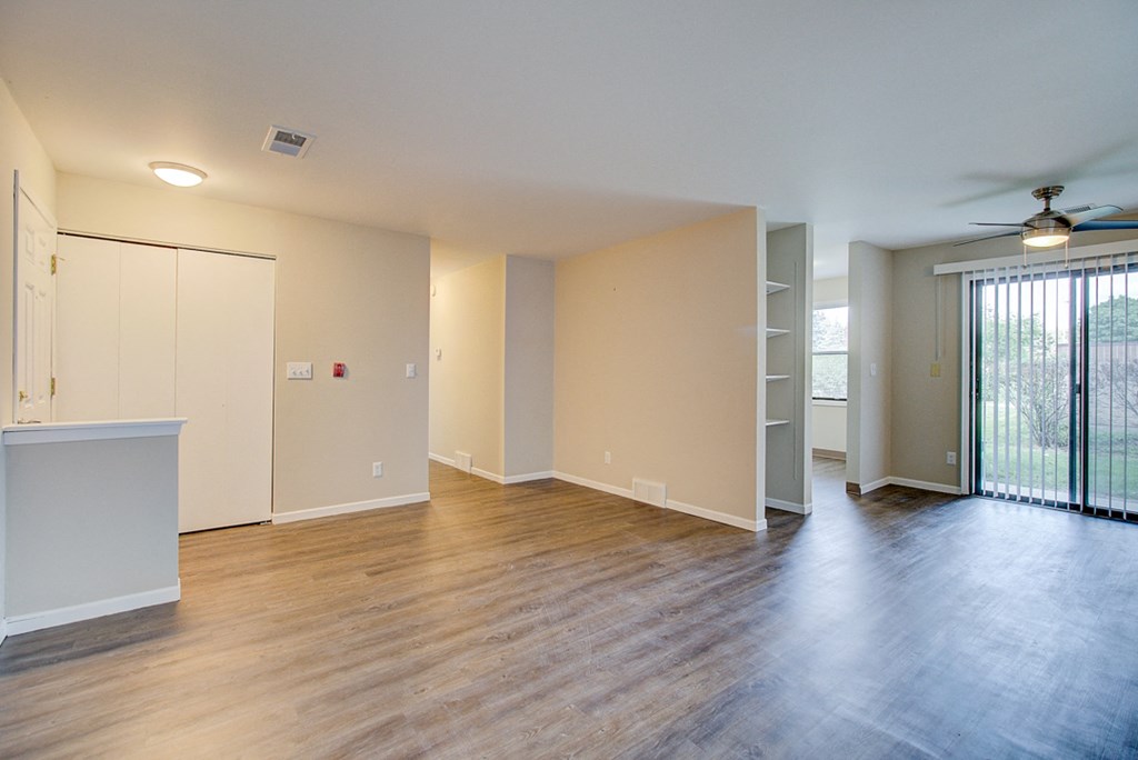 an empty living room with wood floors and a sliding glass door