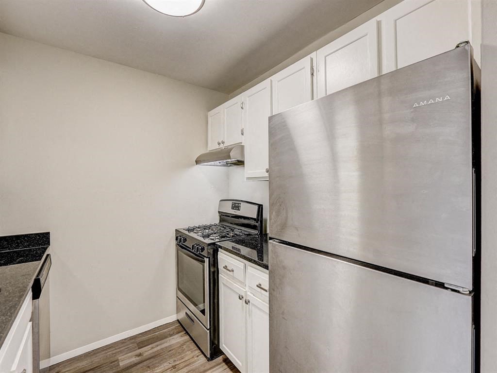 a kitchen with stainless steel appliances and white cabinets