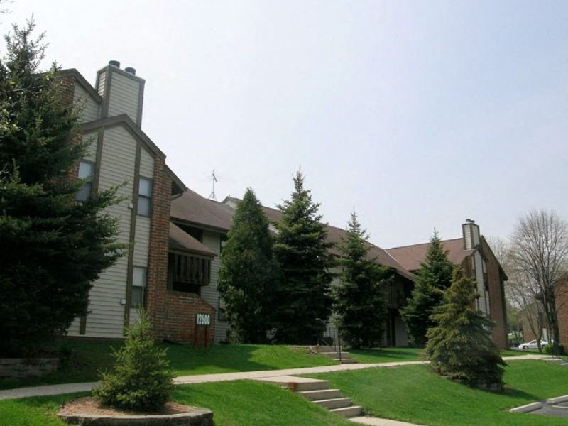 an apartment building with green grass and trees