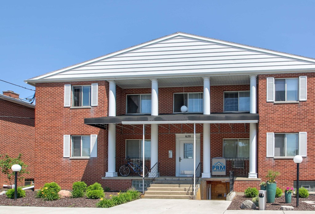the front of a brick building with a porch
