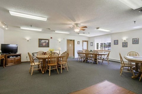 A spacious room with a dining table and chairs.