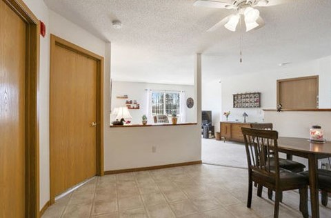 A dining room with a table and chairs.