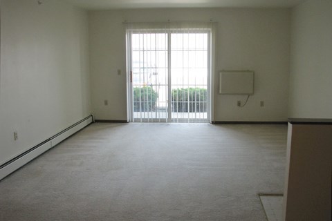 A large empty room with a sliding glass door.