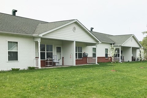 A white house with a red trim and a grey roof.