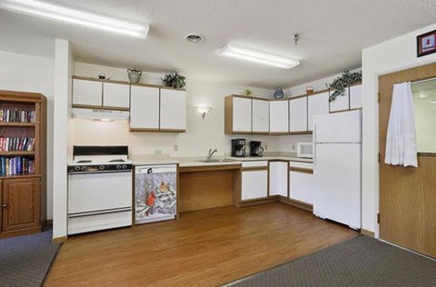 A kitchen with white appliances and wooden cabinets.
