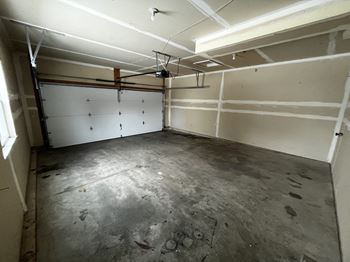 the inside of a garage with a concrete floor and white walls