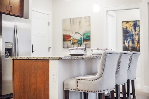A kitchen with a white table and chairs.