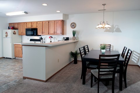 A kitchen with a dining table and chairs.