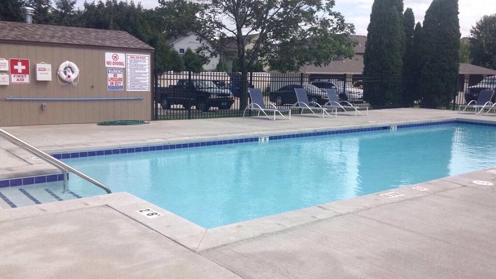 a swimming pool with chairs on the side of it