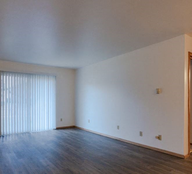 an empty living room with white walls and wood floors