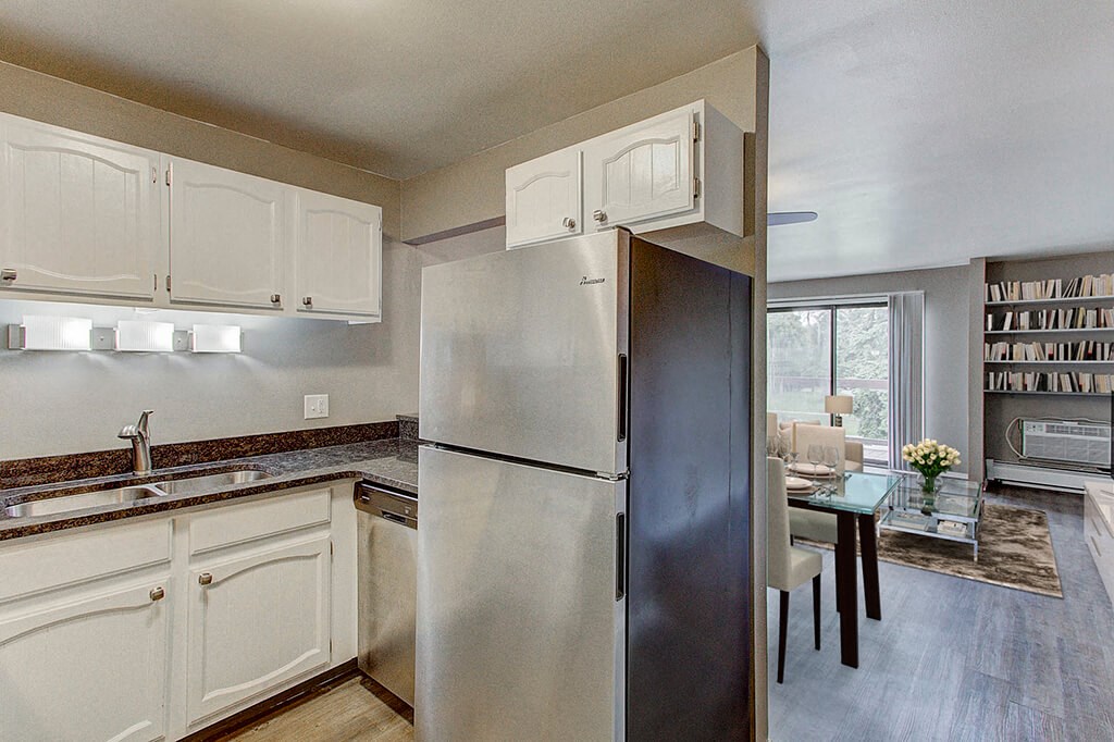 a kitchen with white cabinets and a stainless steel refrigerator