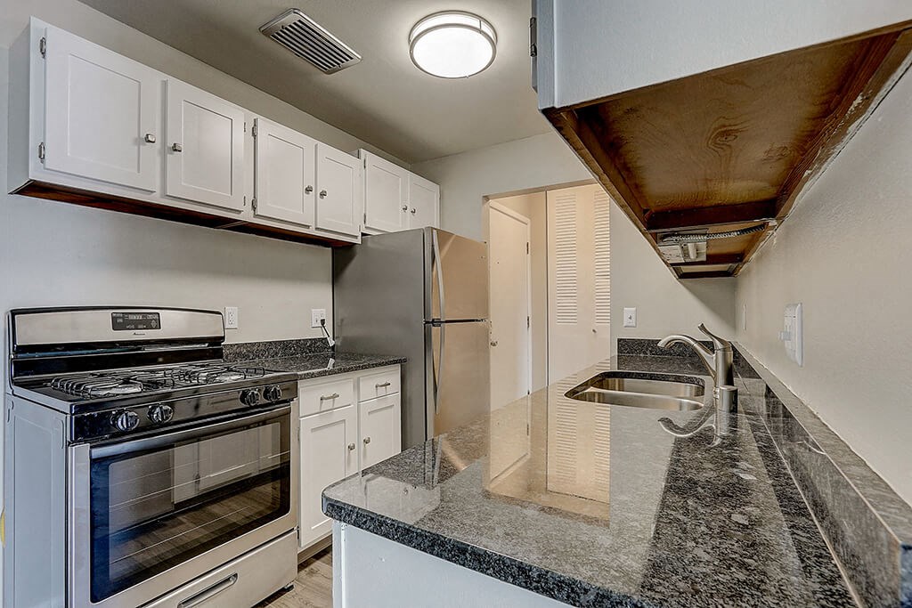 a kitchen with granite counter tops and stainless steel appliances