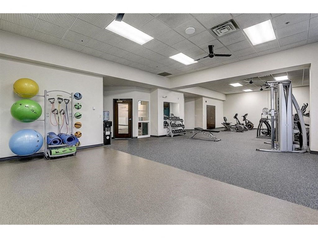 a workout room with weights and other exercise equipment in a large space