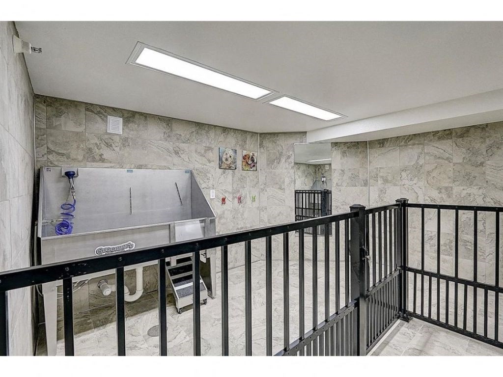 the foyer of the building has a hot tub and a staircase with a railing