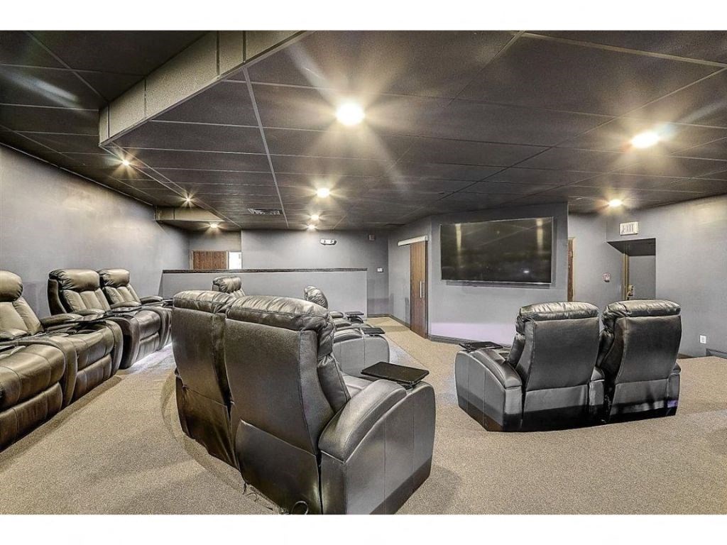 a large screening room with leather chairs and a tv