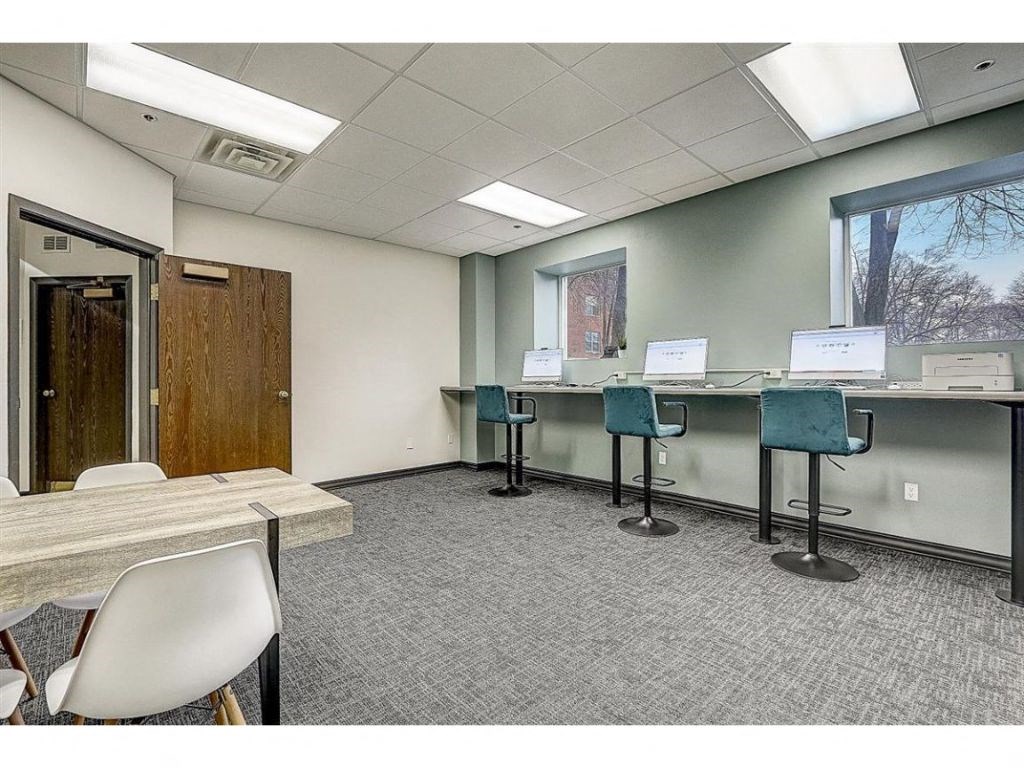 a conference room with desks and chairs and a door
