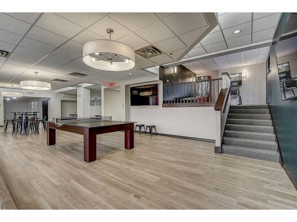a game room with a ping pong table and stairs