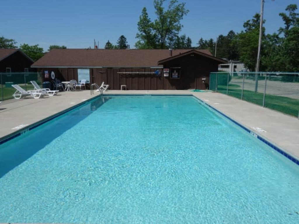 a swimming pool with a house in the background