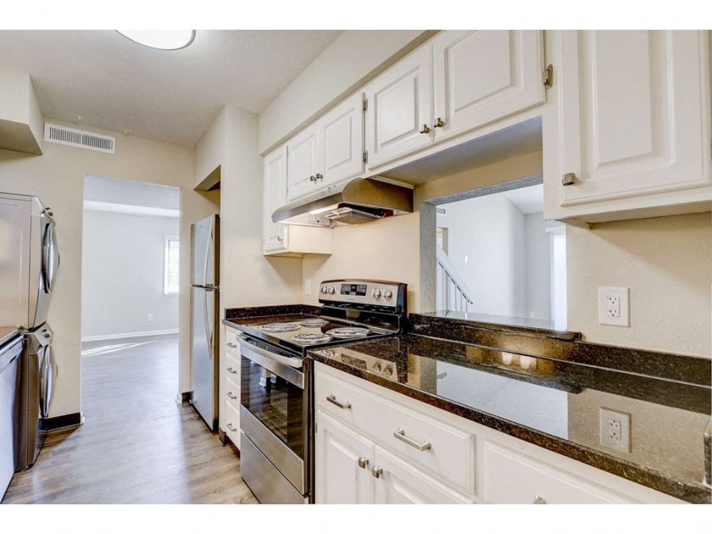 a kitchen with white cabinets and a stove and a refrigerator