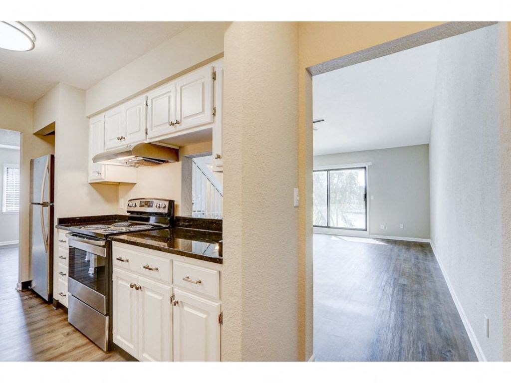 a kitchen with white cabinets and stainless steel appliances