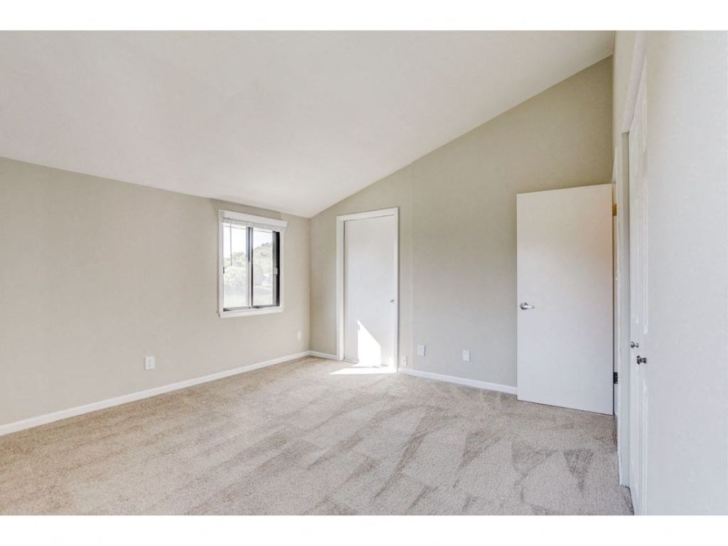 an empty living room with a door to a closet