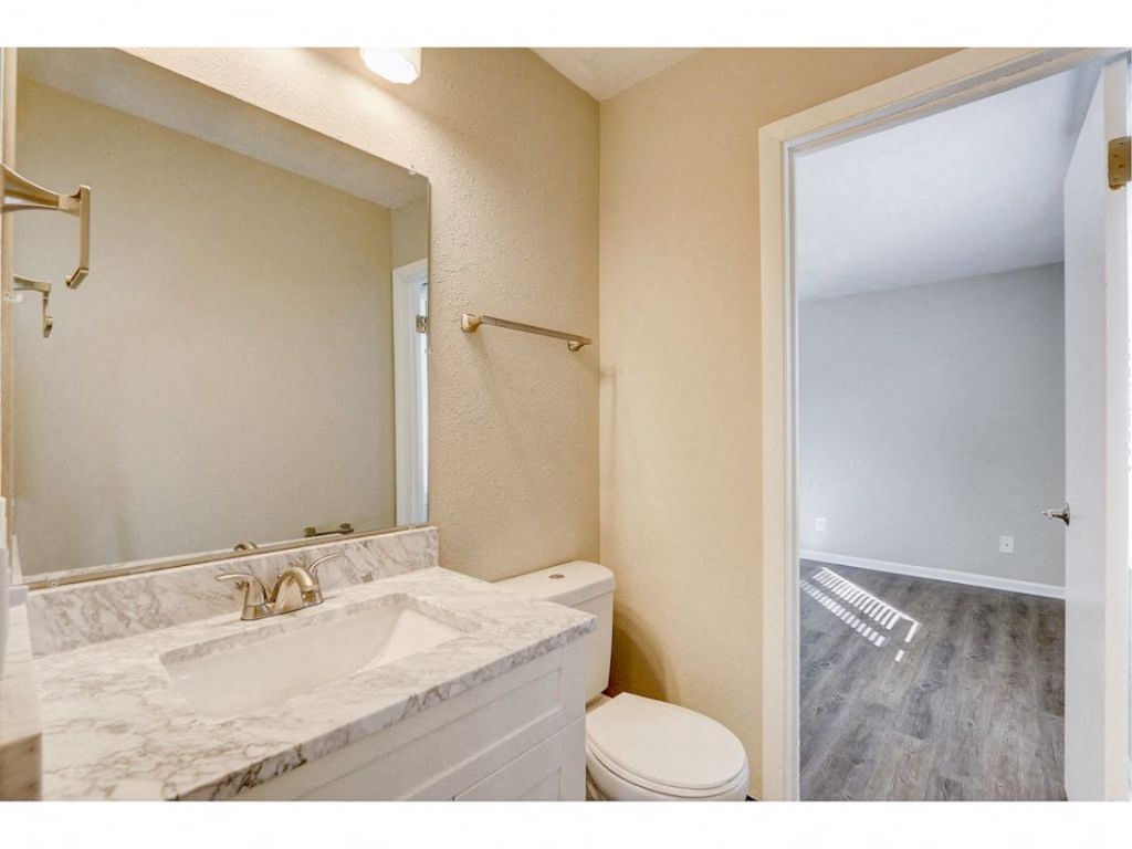 a bathroom with a toilet sink and a mirror