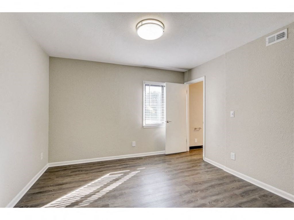 an empty living room with white walls and a window