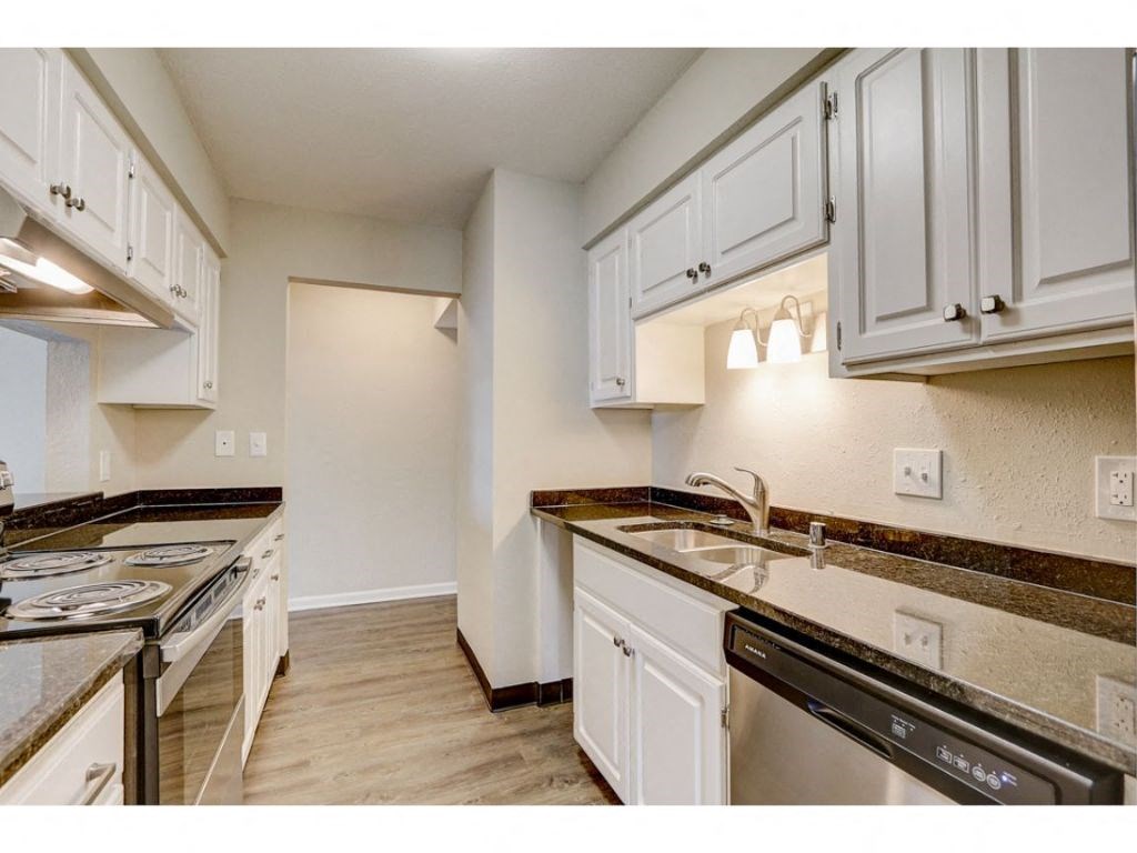 a kitchen with white cabinets and a stove and a sink