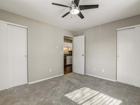 an empty living room with a ceiling fan