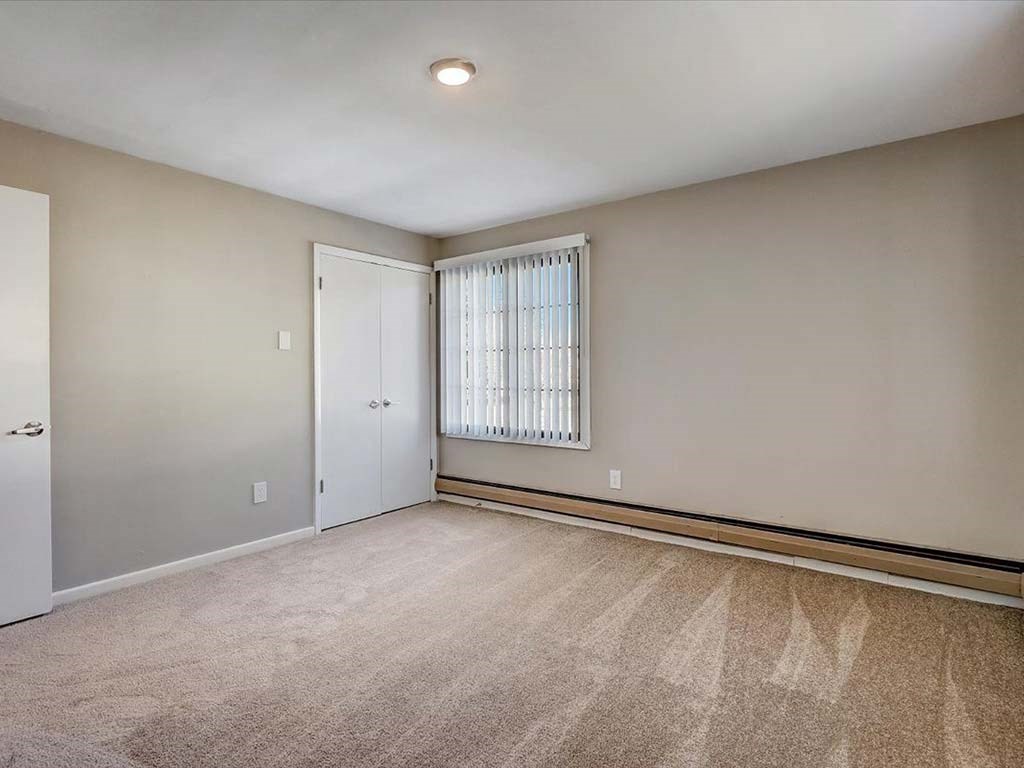 an empty living room with a window and a door