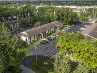 an aerial view of a building with parking lot and trees