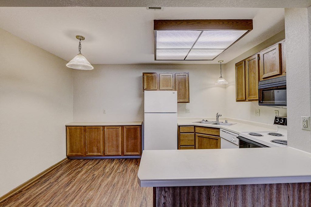an empty kitchen with a stove and a refrigerator