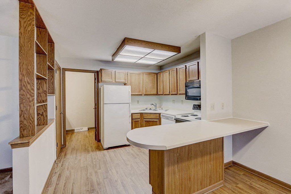 a kitchen with white appliances and wooden cabinets