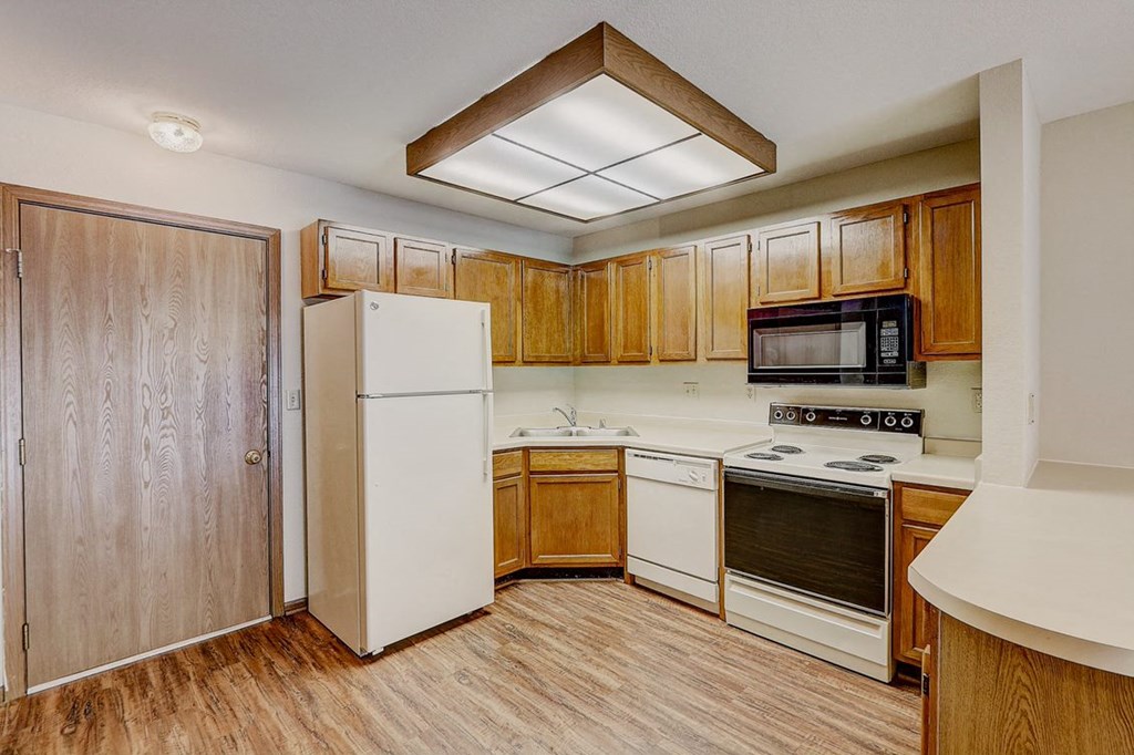 a kitchen with white appliances and wooden cabinets