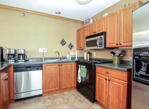 A kitchen with wooden cabinets and a tile floor.