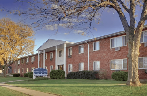 A brick building with a sign that says "Marquette Shores" in front of it.