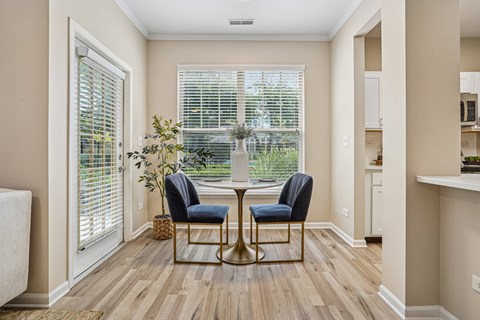 A dining room with a table and chairs.