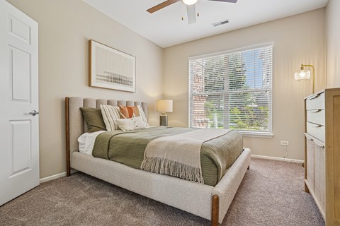 A bedroom with a large bed and a ceiling fan.