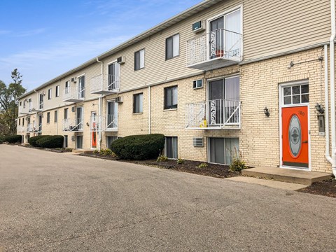 a building with a red door on the side of a street