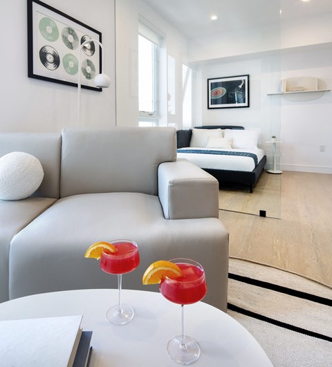 Two drinks are on a table in a living room.