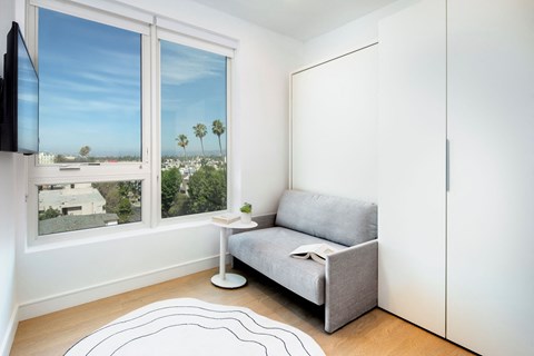 A living room with a grey couch and a television.