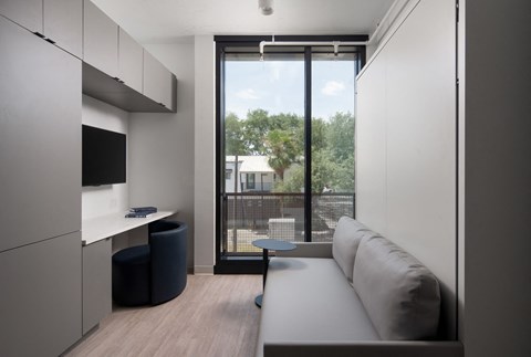 A modern kitchen with a large window overlooking a balcony.