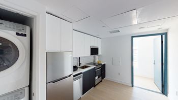 a kitchen with a washing machine and a sink and a refrigerator at Miles at Harvard, California, 90020