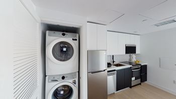 a white kitchen with a washing machine and a washer and dryer at Miles at Harvard, Los Angeles, CA